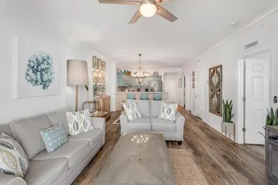a living room with a couch and a ceiling fan at Tropic Winds 1909 in Panama City Beach