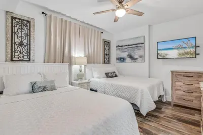 a bedroom with two beds and a ceiling fan at Tropic Winds 1909 in Panama City Beach