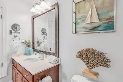 a bathroom with a sink and a mirror at Tropic Winds 1909 in Panama City Beach