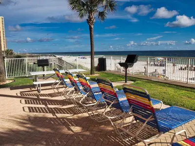a group of lawn chairs sitting in front of the beach at Tropic Winds 1605 in Panama City Beach