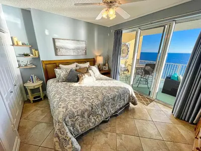 a bedroom with a bed with a view of the ocean at Tropic Winds 1605 in Panama City Beach