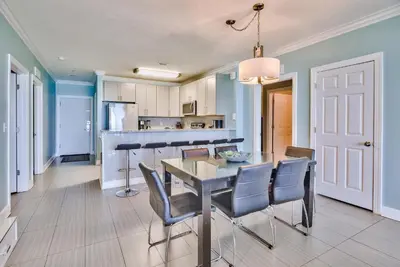 a dining room and kitchen with a table and chairs at Tropic Winds 707 in Panama City Beach