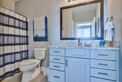 a bathroom with a toilet and a sink and a mirror at Tropic Winds 707 in Panama City Beach