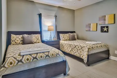 a bedroom with two beds and a window at Tropic Winds 707 in Panama City Beach