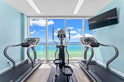 a gym with two treadmill machines in front of a window at Tropic Winds 603 in Panama City Beach
