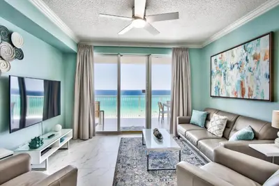 a living room with a couch and a tv at Tropic Winds 603 in Panama City Beach