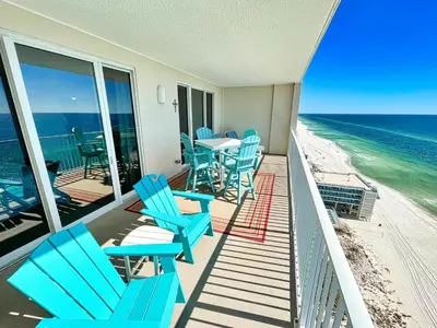 a balcony with blue chairs and a table and the ocean at Ocean Reef 1808 in Panama City Beach