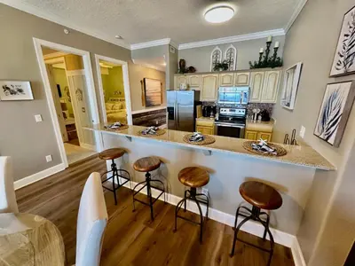 a kitchen with a counter and stools in a room at Ocean Reef 2308 in Panama City Beach