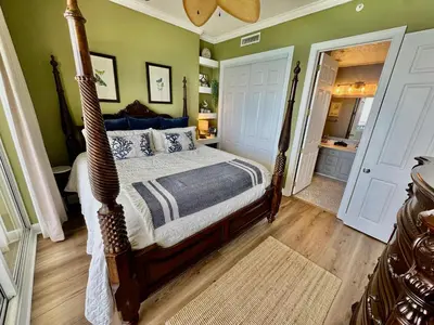 a bedroom with a canopy bed and a bathroom at Ocean Reef 2308 in Panama City Beach