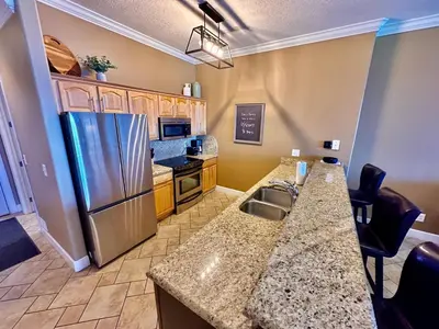 a kitchen with a stainless steel refrigerator and a counter at Ocean Reef 1902 in Panama City Beach