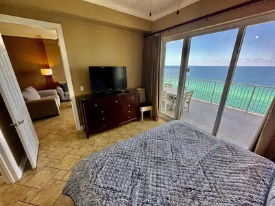 a bedroom with a bed and a view of the ocean at Ocean Reef 1902 in Panama City Beach