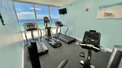 a gym with cardio machines and a view of the ocean at Ocean Reef 1902 in Panama City Beach