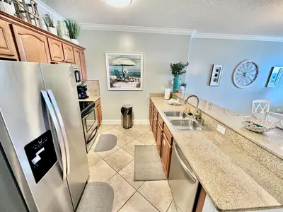 a kitchen with a stainless steel refrigerator and a sink at Ocean Reef 802 in Panama City Beach
