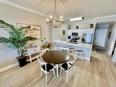 a dining room and kitchen with a table and chairs at Ocean Reef 1907 in Panama City Beach