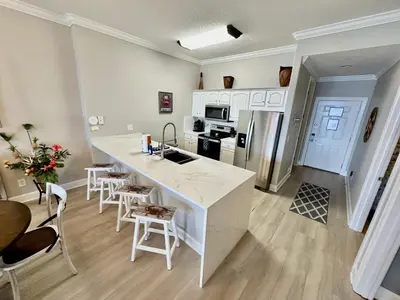 a kitchen with a large white island in a room at Ocean Reef 1907 in Panama City Beach