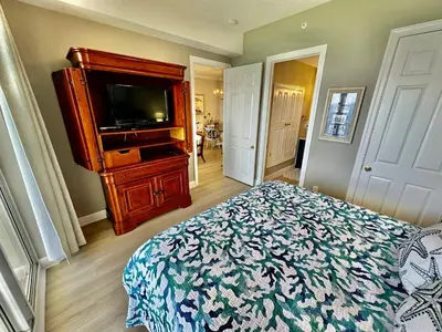 a bedroom with a bed and a flat screen tv at Ocean Reef 1907 in Panama City Beach