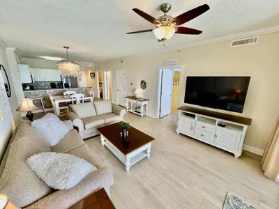 a living room with a couch and a flat screen tv at Tropic Winds 1107 in Panama City Beach