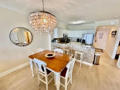a kitchen and dining room with a wooden table and chairs at Tropic Winds 1107 in Panama City Beach