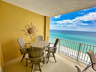 a balcony with a table and chairs and the ocean at Tropic Winds 1107 in Panama City Beach