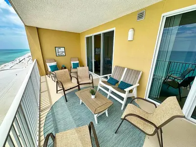 a balcony with chairs and a table and the ocean at Tropic Winds 1107 in Panama City Beach