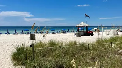 a beach with a gazebo and chairs and the ocean at Ocean Reef 2103 in Panama City Beach