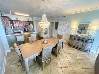 a dining room with a wooden table and chairs at Tropic Winds 809 in Panama City Beach