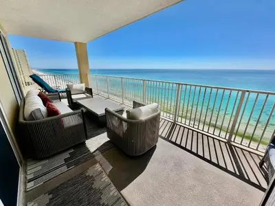 a balcony with chairs and a view of the ocean at Tropic Winds 1201 in Panama City Beach