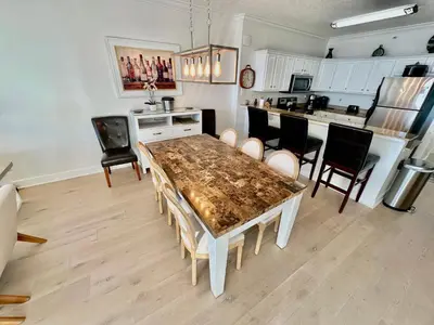 a kitchen and dining room with a table and chairs at Tropic Winds 1201 in Panama City Beach