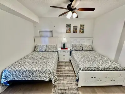 a bedroom with two beds and a ceiling fan at Tropic Winds 1201 in Panama City Beach