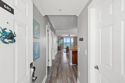 a hallway with white doors and wood floors at Tropic Winds 605 in Panama City Beach