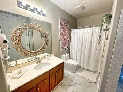 a bathroom with a sink and a mirror and a toilet at Ocean Reef 2204 in Panama City Beach