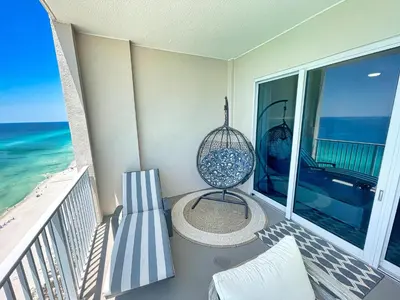 a balcony with a chair and a swing at Ocean Reef 2204 in Panama City Beach
