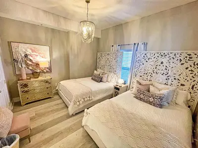 a bedroom with two beds and a chandelier at Ocean Reef 2204 in Panama City Beach