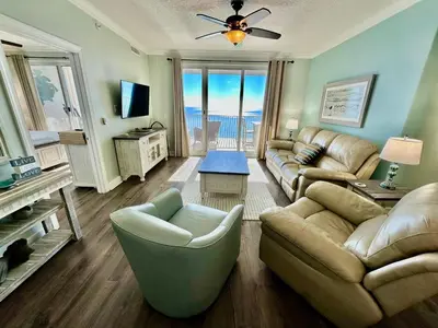 a living room with a couch and chairs and a television at Ocean Reef 1705 in Panama City Beach