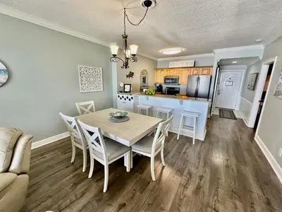 a kitchen and dining room with a table and chairs at Ocean Reef 1705 in Panama City Beach