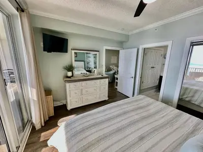a bedroom with a bed and a sink and a mirror at Ocean Reef 1705 in Panama City Beach
