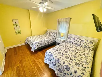 a bedroom with two beds and a ceiling fan at Tropic Winds 1706 in Panama City Beach