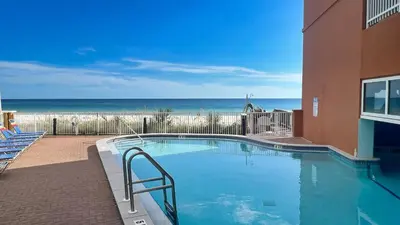 a swimming pool with the beach in the background at Tropic Winds 1706 in Panama City Beach