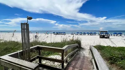a wooden bench on the beach near the beach at Tropic Winds 1706 in Panama City Beach