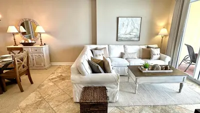 a living room with a white couch and a table at Tropic Winds 1606 in Panama City Beach
