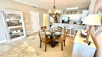 a kitchen and dining room with a table and chairs at Tropic Winds 1606 in Panama City Beach