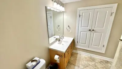 a bathroom with a sink and a mirror and a toilet at Tropic Winds 1606 in Panama City Beach