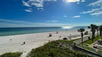 a view of a beach with palm trees and the ocean at Tropic Winds 1606 in Panama City Beach