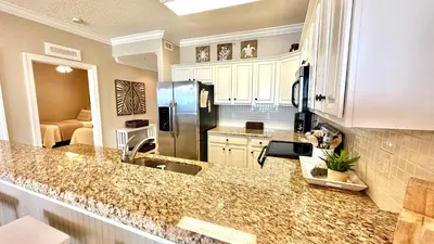 a kitchen with a counter top and a refrigerator at Tropic Winds 1606 in Panama City Beach