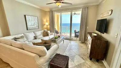 a living room with a white couch and a television at Tropic Winds 1606 in Panama City Beach