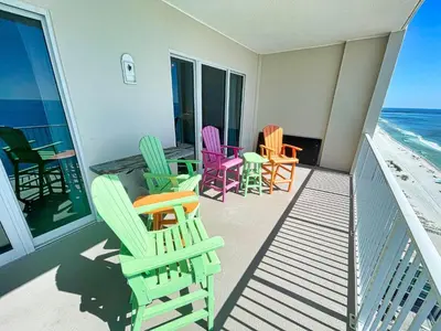 a balcony with colorful chairs and tables on the beach at Ocean Reef 1903 in Panama City Beach