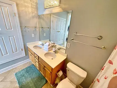 a bathroom with a sink and a toilet and a mirror at Ocean Reef 1903 in Panama City Beach