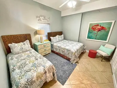 a bedroom with two beds and a chair in it at Ocean Reef 1903 in Panama City Beach