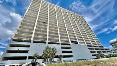 a large white building with trees in front of it at Ocean Reef 1903 in Panama City Beach