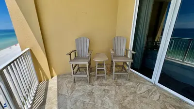 a couple of chairs sitting on a balcony at Tropic Winds 904 in Panama City Beach